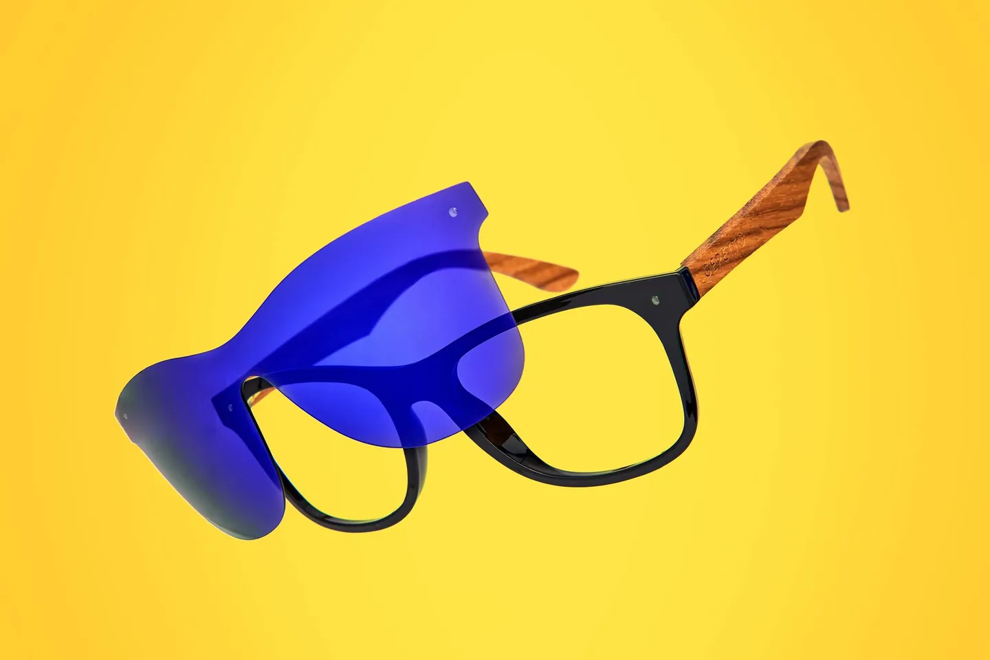 Okulary Gepetto Eyewear z niebieską nakładką na żółtym tle.